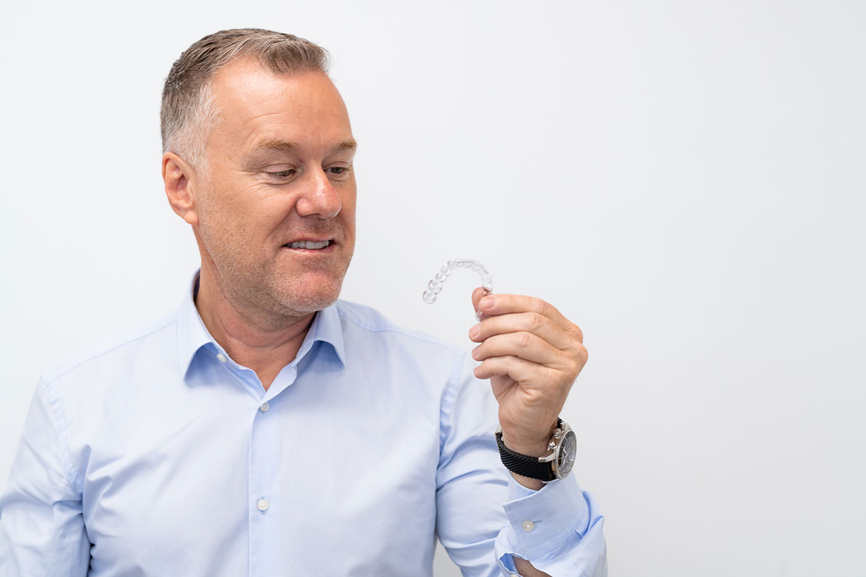 Man holding Invisalign Aligners
