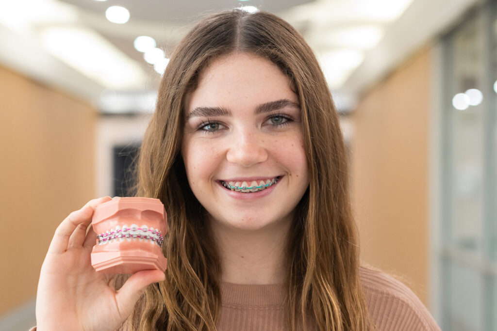 A girl showing the model of braces