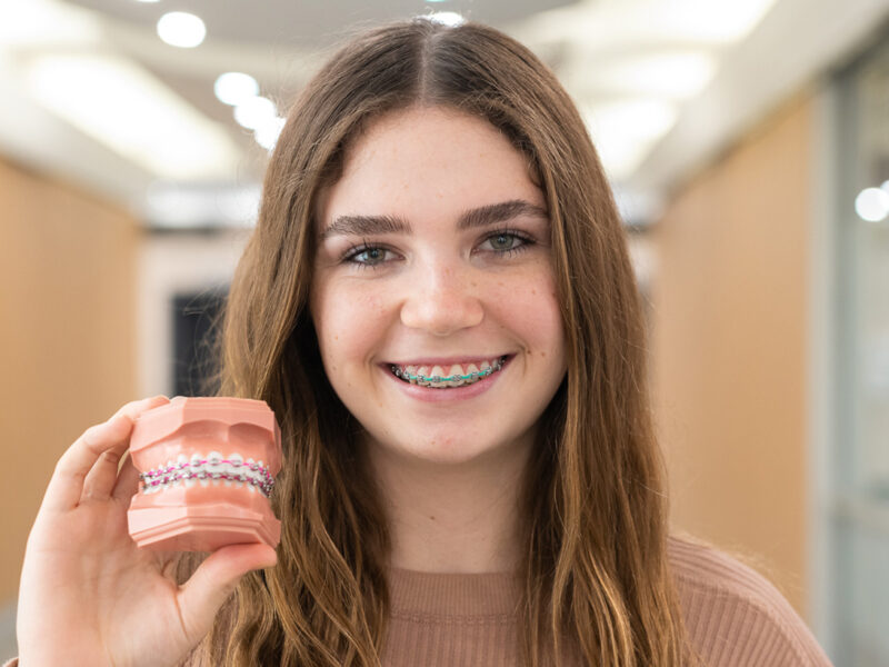 A girl showing the model of braces